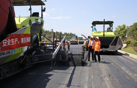 攤鋪機(jī)、壓路機(jī)等設(shè)備緊張有序運(yùn)行，高達(dá)170℃的瀝青混合料炙烤著公路人